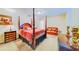 Second bedroom with four-poster bed, leather couch, and elegant decor at 1135 Candler Rd, Clearwater, FL 33765