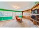 Bonus room featuring green walls, built-in shelves, a large TV, and plush carpeting at 1135 Candler Rd, Clearwater, FL 33765