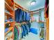 Walk-in closet with built-in wooden shelves, hanging rods, and storage at 1135 Candler Rd, Clearwater, FL 33765