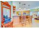 Kitchen with granite countertops, breakfast bar, wood cabinets, pendant lights, and decorative mirror at 1135 Candler Rd, Clearwater, FL 33765