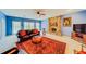 Living room with a brick fireplace, leather furniture, and blue walls, leading out to a pool area at 1135 Candler Rd, Clearwater, FL 33765