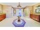 Spacious main bathroom with double vanity, glass shower, and unique rug at 1135 Candler Rd, Clearwater, FL 33765
