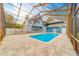 Large pool with a screened enclosure and paver patio, perfect for outdoor entertaining at 1135 Candler Rd, Clearwater, FL 33765