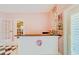 Sunroom bar area with pink wood-paneled walls and black and white checkered floor at 1135 Candler Rd, Clearwater, FL 33765