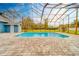 Inviting pool area with screened enclosure and brick pavers at 1135 Candler Rd, Clearwater, FL 33765