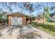 House exterior showcasing a single-story home with a garage and well-maintained lawn at 209 Orange Dr, Lutz, FL 33548