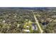Aerial view of a property with lush landscaping and a pond nearby at 2501 Rustic Oaks Dr, Lutz, FL 33559