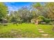 Expansive backyard with a charming bridge feature, lush greenery, and serene ambiance at 2501 Rustic Oaks Dr, Lutz, FL 33559