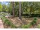 Spacious backyard featuring mature trees, a picnic table, and a separate outbuilding for versatile use at 2501 Rustic Oaks Dr, Lutz, FL 33559