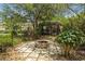 Charming backyard fire pit area surrounded by lush landscaping, creating a relaxing outdoor space at 2501 Rustic Oaks Dr, Lutz, FL 33559