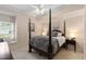 Bedroom with decorative four-poster bed, neutral paint, and lots of natural light at 2501 Rustic Oaks Dr, Lutz, FL 33559