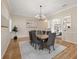 Traditional dining room featuring a wood table, six chairs, modern chandelier, and access to other rooms at 2501 Rustic Oaks Dr, Lutz, FL 33559