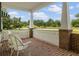Relaxing front porch featuring brick flooring, white railing, and comfortable wicker chairs at 2501 Rustic Oaks Dr, Lutz, FL 33559