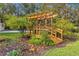 A quaint wooden bridge amidst lush gardens, adding a touch of whimsical charm to the landscaped yard at 2501 Rustic Oaks Dr, Lutz, FL 33559