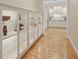 Hallway featuring hardwood floors, custom cabinets with glass shelves, and neutral paint at 2501 Rustic Oaks Dr, Lutz, FL 33559