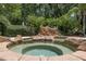 Relaxing rock-enclosed hot tub surrounded by lush landscaping for ultimate privacy at 2501 Rustic Oaks Dr, Lutz, FL 33559