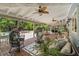 Covered outdoor patio with comfortable seating and a relaxing view of the landscaped backyard at 2501 Rustic Oaks Dr, Lutz, FL 33559