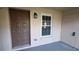 Exterior view of condo entryway with brown door and window at 3020 Bonaventure Cir # 102, Palm Harbor, FL 34684