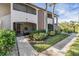 Inviting condo building exterior with lush landscaping and walkway at 3020 Bonaventure Cir # 102, Palm Harbor, FL 34684