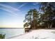 White sandy beach with lush trees and calm water along the shoreline at 508 Park Blvd, Oldsmar, FL 34677