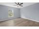 Bright bedroom featuring wood-look floors and a ceiling fan at 6489 Hazelwood Rd, Spring Hill, FL 34608