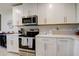Modern kitchen with white cabinets, island, and stainless steel appliances at 18027 Turning Leaf Cir, Land O Lakes, FL 34638