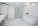 Spa-like bathroom with freestanding tub, shower, and marble floors at 455 Pinellas Bayway S # 2B, Tierra Verde, FL 33715