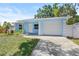 Light blue home with a white garage door, a front garden, and a walkway leading to the front door at 615 W Virginia Ave, Tampa, FL 33603