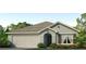 One-story home with attached garage, landscaping, and neutral color palette at 713 Ace Outlaw Ave, Ruskin, FL 33570