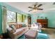 Bright living room with large windows, comfortable furniture, and a decorative ceiling fan at 7255 18Th Ne St, St Petersburg, FL 33702