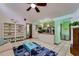 Bright living room with a ceiling fan, a bookshelf, and an adjacent modern kitchen with a breakfast bar at 7255 18Th Ne St, St Petersburg, FL 33702