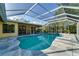 Backyard screened-in pool with a gray stone patio and a view of the house at 7255 18Th Ne St, St Petersburg, FL 33702