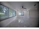 Bright living room featuring large windows, tile floors, and a ceiling fan at 1042 Idlewild N Dr, Dunedin, FL 34698