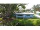Aerial view of a renovated light blue house and yard at 1042 Idlewild N Dr, Dunedin, FL 34698