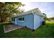 Newly renovated light blue house exterior with a stone patio at 1042 Idlewild N Dr, Dunedin, FL 34698