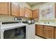Laundry room with Whirlpool washer and dryer and cabinets at 12709 Mannhurst Oak Ln, Lithia, FL 33547