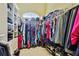 Walk-in closet with custom shelving and hanging rods at 12709 Mannhurst Oak Ln, Lithia, FL 33547