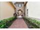 Elegant entryway with stone arch and pathway leading to courtyard at 12709 Mannhurst Oak Ln, Lithia, FL 33547