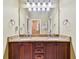 Double vanity bathroom with granite countertop and large mirror at 12709 Mannhurst Oak Ln, Lithia, FL 33547