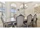 Elegant formal dining room featuring a large table with seating for eight and a beautiful chandelier at 12709 Mannhurst Oak Ln, Lithia, FL 33547