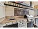 Outdoor kitchen with built-in grill, sink, and stone countertops at 12709 Mannhurst Oak Ln, Lithia, FL 33547