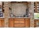 Kitchen cooktop with brick accent wall and extensive storage at 12709 Mannhurst Oak Ln, Lithia, FL 33547