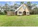 Charming guest house with a rustic exterior and well maintained lawn at 12709 Mannhurst Oak Ln, Lithia, FL 33547