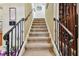 Elegant staircase with wrought iron railing leading to the upper level at 12709 Mannhurst Oak Ln, Lithia, FL 33547