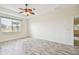 Spacious bedroom featuring wood-look floors and a ceiling fan at 13141 Palmilla Cir, Dade City, FL 33525