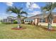 Home's backyard boasts lush landscaping, palm trees, and a view of a neighboring house at 13141 Palmilla Cir, Dade City, FL 33525