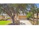 Exterior of a house with a tan garage door, stone accents, and lush landscaping at 13141 Palmilla Cir, Dade City, FL 33525