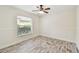 Well-lit bedroom featuring wood-look floors and a window at 13141 Palmilla Cir, Dade City, FL 33525