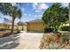 Exterior view of house with tan garage, stone accents, and landscaping at 13141 Palmilla Cir, Dade City, FL 33525
