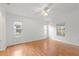 Bright bedroom featuring wood floors and two windows at 13229 Golf Ridge Pl, Hudson, FL 34669